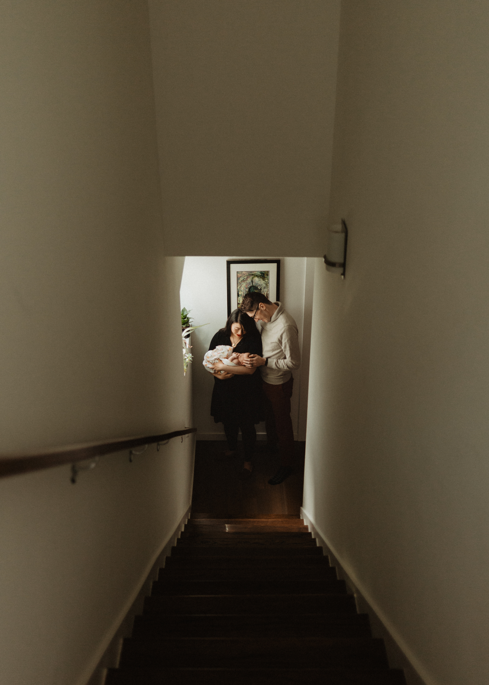 Newborn family portrait at home, photographed through a stairwell